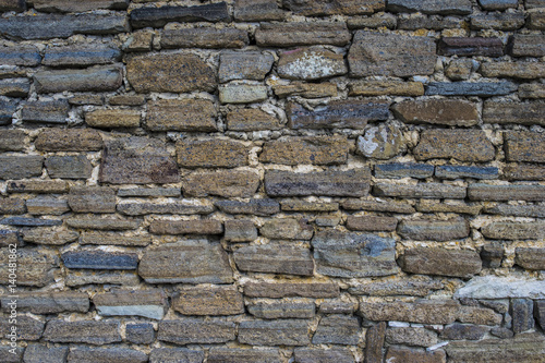 Ancient old dark regular stone wall