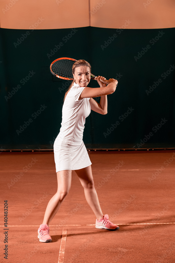 Sportswoman at the tennis court with racquet.