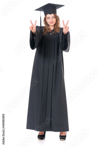 Beautiful graduate girl student in mantle showing victory sign, isolated on white background