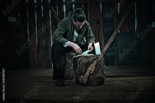 Canvas Print Man Sitting on Trunk Tree and Reading Bible