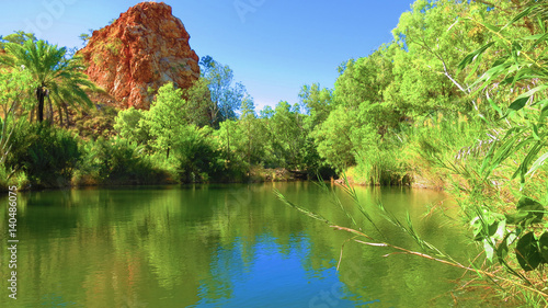 River with rock formation in background and plantations near Palm Springs campsite in halls creek, Western Australia photo