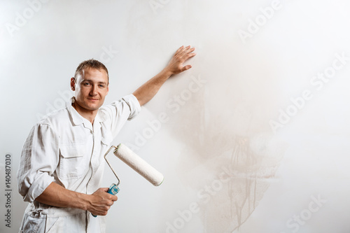 Worker looking at camera, holding roller. Copy space.