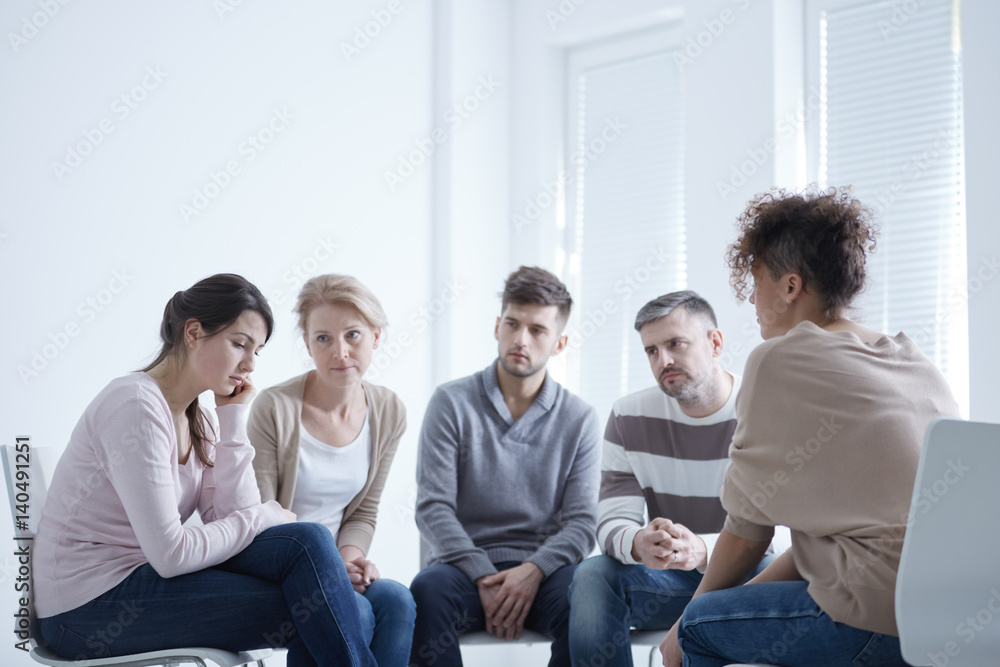 Fototapeta premium Grupa wspierająca smutną kobietę