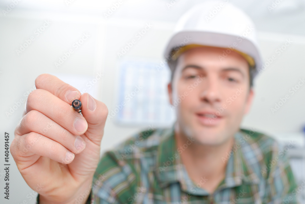 Builder holding up a pen Builder holding up a pen