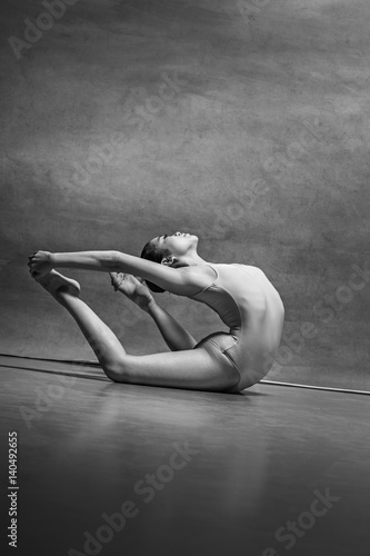 The female ballet dancer posing over gray background