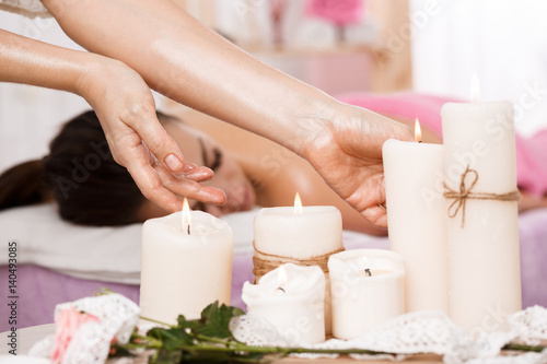 Closeup photo of female hands taking candles at spa salon 