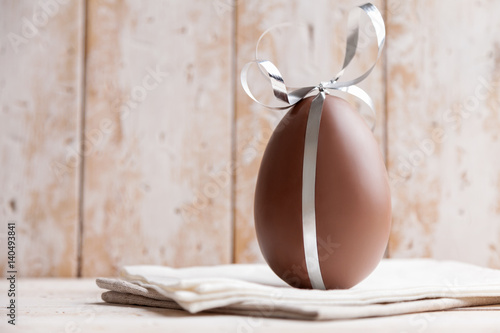 Delicious chocolate Easter egg with a ribbon photo