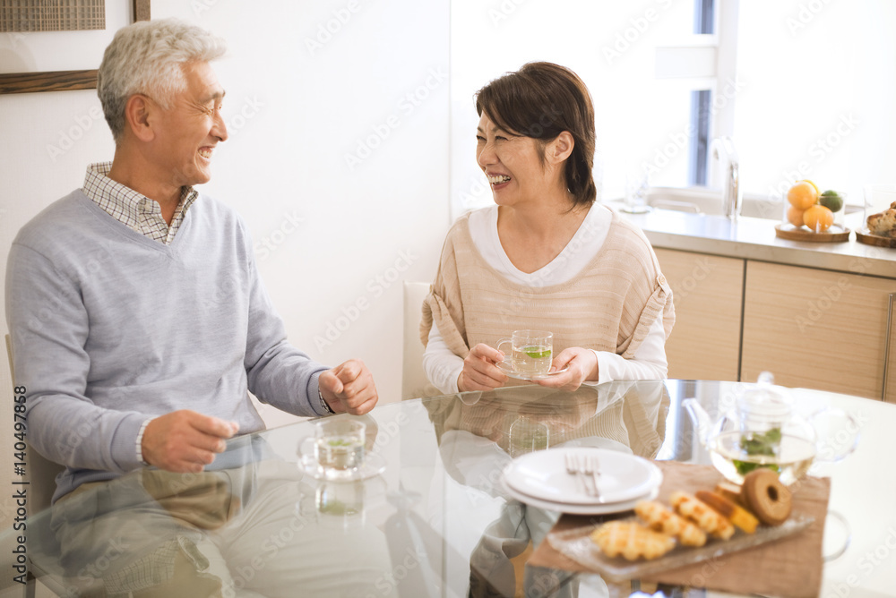 Senior couple drinking tea at dining table, smiling Senior couple drinking tea at dining table, smiling