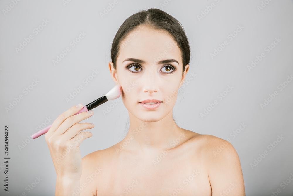 Fototapeta premium Beauty portrait of young, attractive, fresh, healthy and natural woman with the makeup brush 