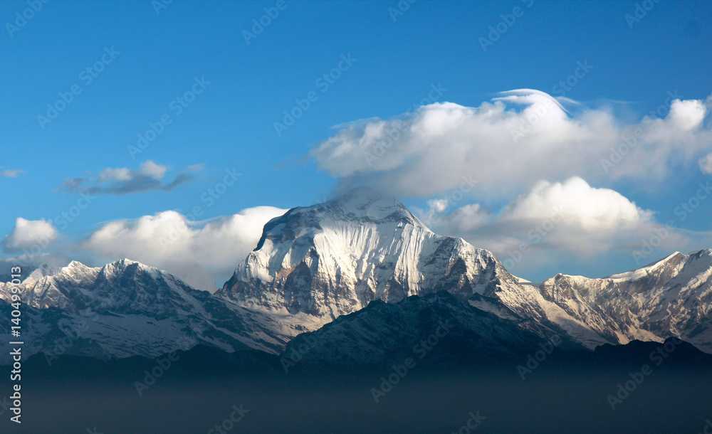 white clouds in the blue sky over the snowy summits of Annapurna,Nepal