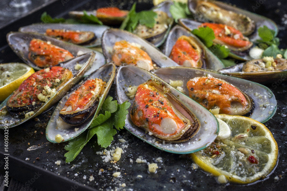 Baked Green Shell Mussels as close-up on old rustic sheet Baked Green Shell Mussels as close-up on old rustic sheet