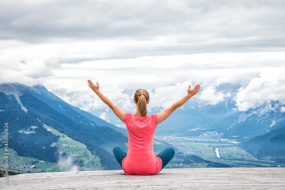 young woman meditate on top of the mountain young woman meditate on top of the mountain
