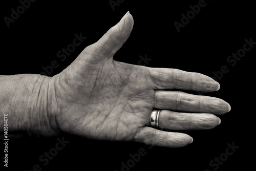 Mature woman's hand in greeting gesture. Black and white.