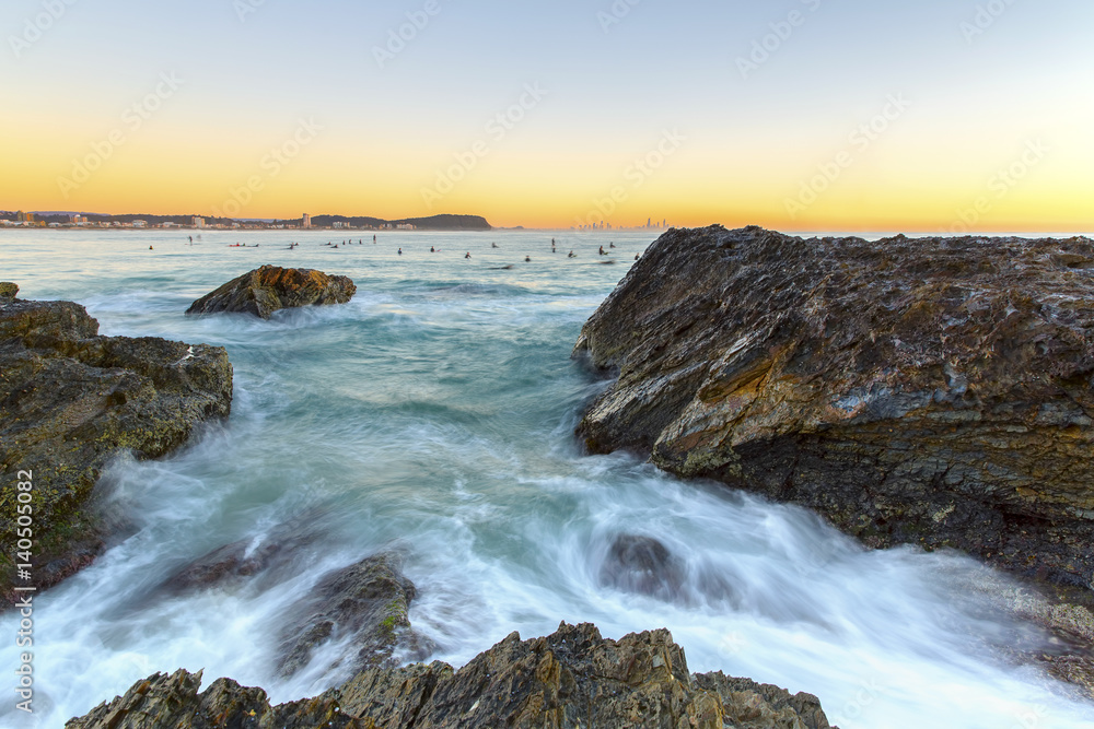 Currumbin Rock Gold Coast clear sky sunrise with incoming ocean rushing against the rocks