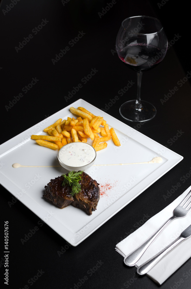 Beef steak with French fries on a white plate Beef steak with French fries on a white plate