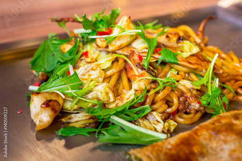 Japanese yakisoba noodles with seafood grilled on the iron griddle called teppanyaki photo