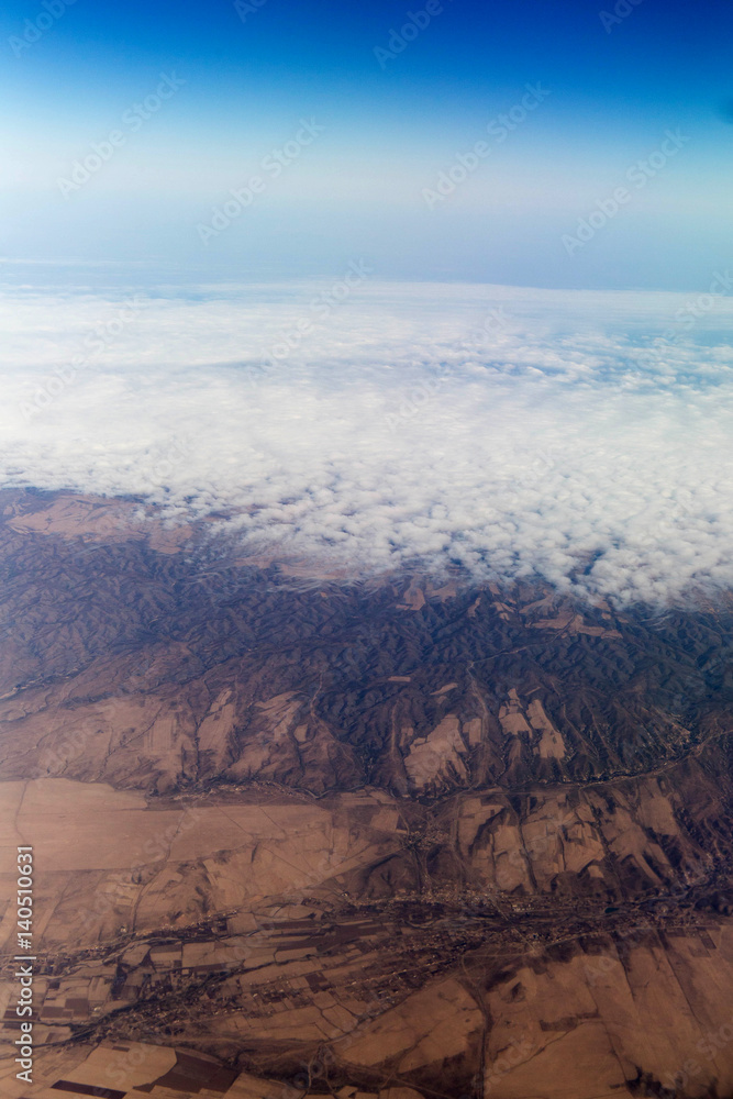 Clouds mountains and sky as seen through window of an aircraft of uzbekistan