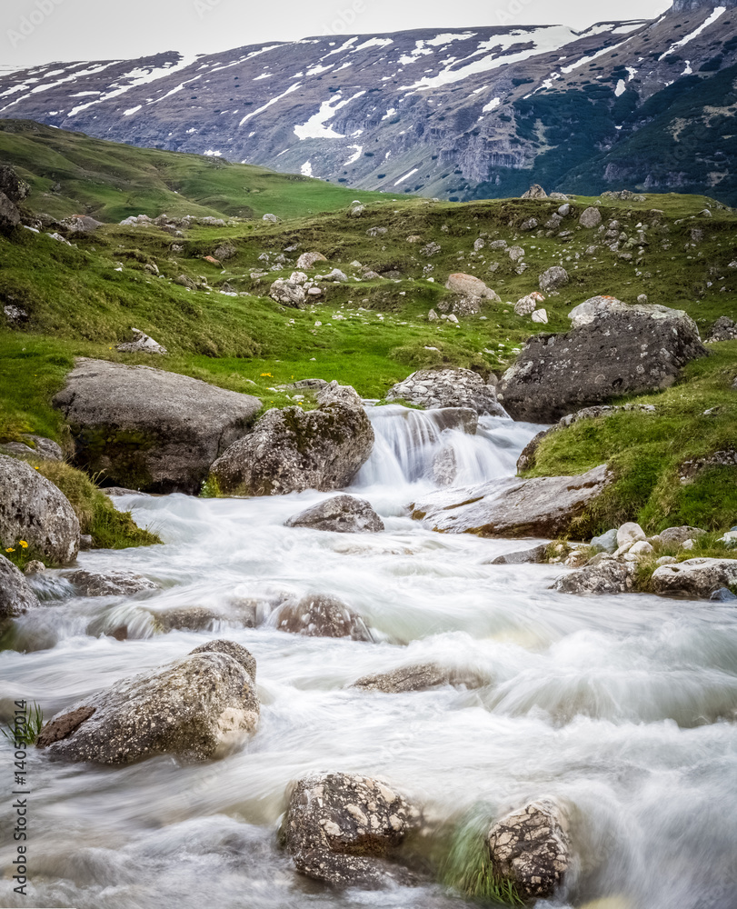 Romania. nature in springtime. mountain scenery, outdoors Romanian landscape in spring with a stream, flowing water,rocks, peaks, green grass .Carpathians on a spring background