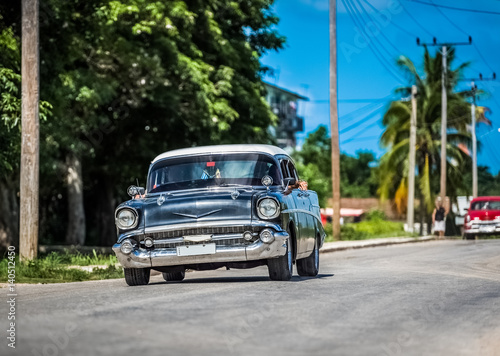 HDR - Schwarzer amerikanischer Chevrolet Oldtimer mit weissem Dach fährt auf der Landstraße im Vorort von Santa Clara Kuba - Serie Kuba Reportage