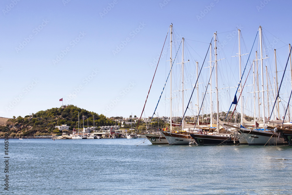 Luxury yachts and sail boats parked at Bodrum marina in a sunny summer day. The city is on the Bodrum Peninsula, stretching from Turkey's southwest coast into the Aegean Sea.