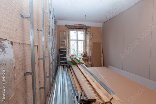 Interior of apartment with materials during on the renovation and construction ( remodel wall from gypsum plasterboard) photo