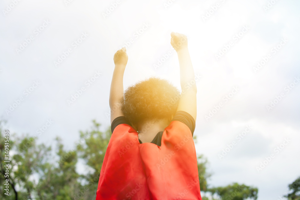 Superhero leader kid raising two hands up in the sky - success and winning achievement concept