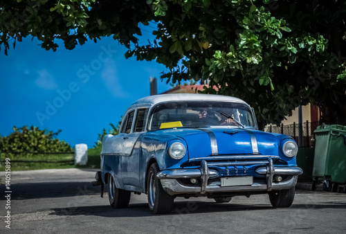 HDR - Blauer Oldtimer mit weissem Dach fährt durch die Vorstadt in Varadero Kuba - Serie Kuba Reportage
