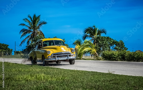 Amerikanischer gelber Oldtimer fährt auf der Küstenstraße nach Santa Clara Kuba - Serie Kuba Reportage © mabofoto@icloud.com