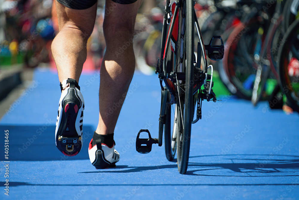 Obraz premium Running triathlete in the transition zone,triathlon bike the transition zone