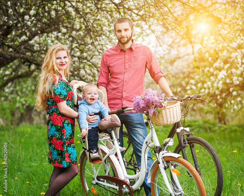 Young family on a bicycles in the spring garden © anatoliy_gleb