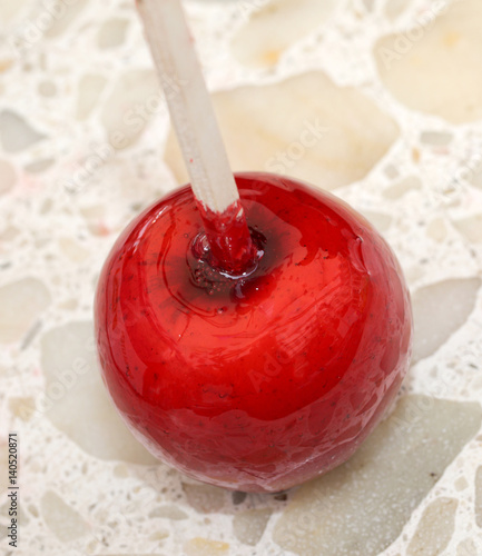 caramelized red apple with wooden stick photo