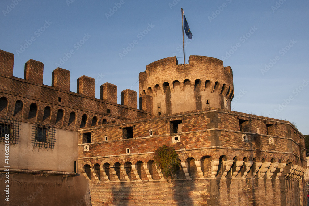 Turrets of Castle San Angelo, alongside the Tiber River in Rome, Italy. Golden late afternoon lighting.