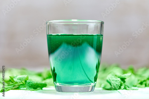 Green chlorophyll drink in glass with water
