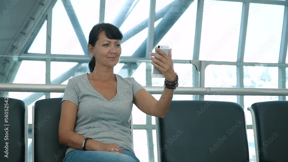 Smiling woman making selfie at empty airport waiting area. Full HD slow motion stock footage.
Smiling woman making selfie at empty airport waiting area. Full HD slow motion stock footage.