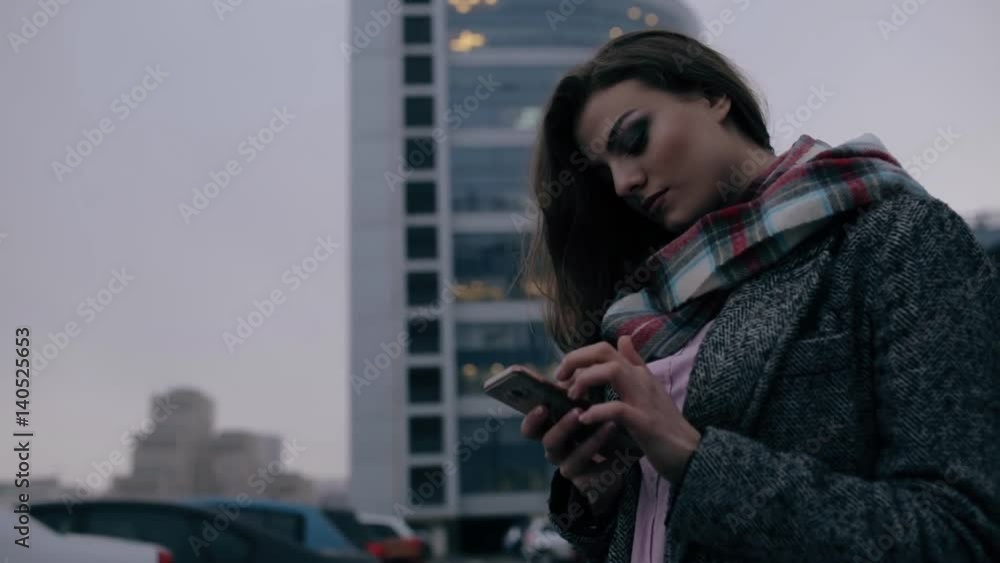 Young woman looking down to smart phone in downtown Young woman looking down to smart phone in downtown