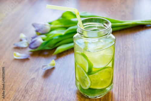 Photos Lime cocktail in jar and bouquet of tulips