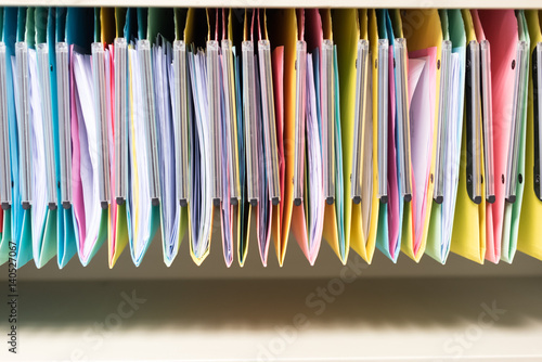 set of multi colored folders / files in metal enclosure / closet