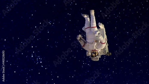 An astronaut or space tourist in spacesuit spinning out of control lost in outer space photo