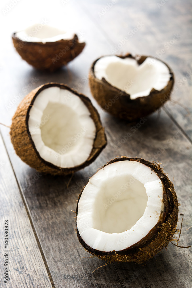 Half coconuts fruit on wooden background
Half coconuts fruit on wooden background
