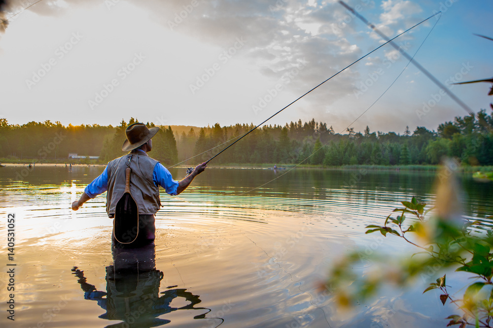 Young man flyfishing at sunrise Young man flyfishing at sunrise