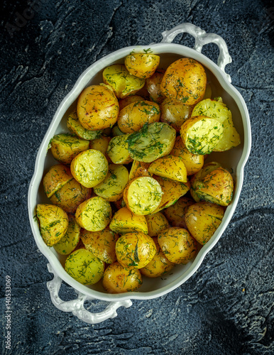 New boiled potatoes with dill and butter in vintage casserole