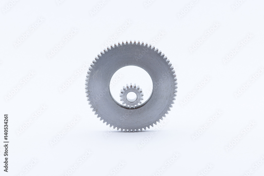 Isolated metal pinions gear. The iron gear on a white background. Pinions in the gearbox. Parts to the gear mechanism. Sprockets to clockwork. Shiny gear ready for assembly. Isolated metal pinions gear. The iron gear on a white background. Pinions in the gearbox. Parts to the gear mechanism. Sprockets to clockwork. Shiny gear ready for assembly.