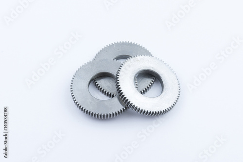 Isolated metal pinions gear. The iron gear on a white background. Pinions in the gearbox. Parts to the gear mechanism. Sprockets to clockwork. Shiny gear ready for assembly.