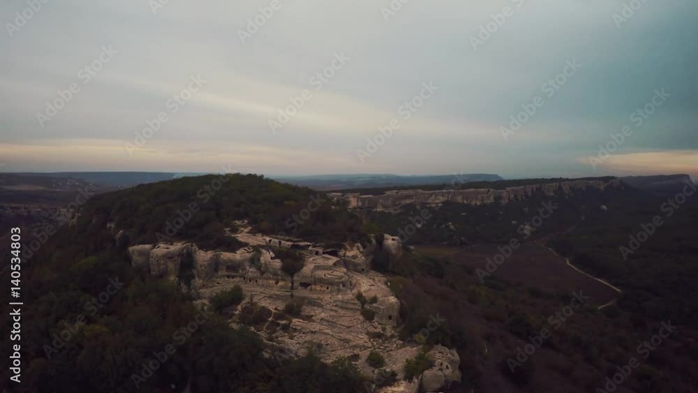 Epic Aerial view of Eski-Kermen. The ruins of the ancient city Mangup Kale. Cloudy sky evening. Mountain Mangup, Crimea. Epic Aerial view of Eski-Kermen. The ruins of the ancient city Mangup Kale. Cloudy sky evening. Mountain Mangup, Crimea.