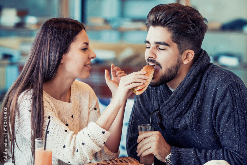 Happy young couple having breakfast in cafe Happy young couple having breakfast in cafe