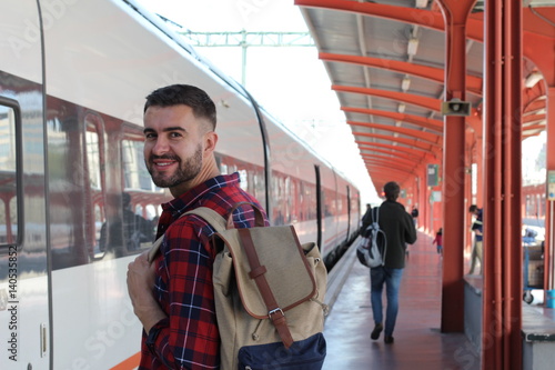 Handsome man smiling about to take a train