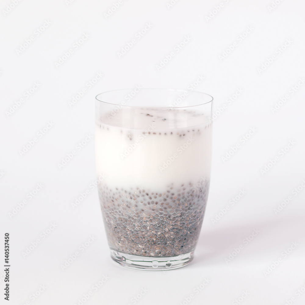 Chia pudding with chia seeds and milk in a glass on white background. Chia pudding with chia seeds and milk in a glass on white background.