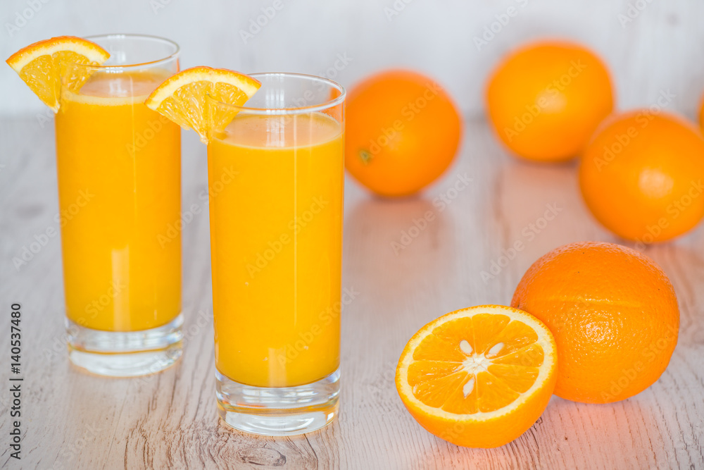 orange juice in glasses at light wooden background orange juice in glasses at light wooden background