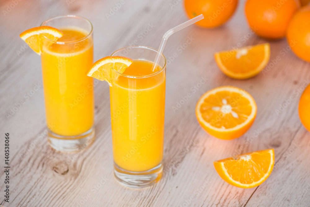 orange juice in glasses at light wooden background orange juice in glasses at light wooden background