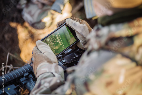 Фотография soldiers holding gps in hand and determines the location of coordinates